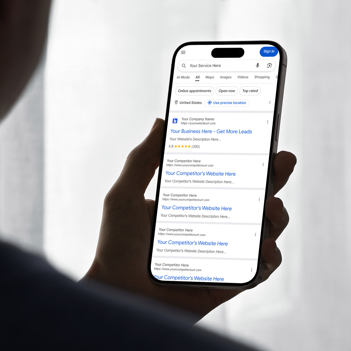 A person holding a smartphone displaying a Google search results page with listings for "Your Business Here" and "Your Competitor's Website Here" after searching "SEO Lansing MI.