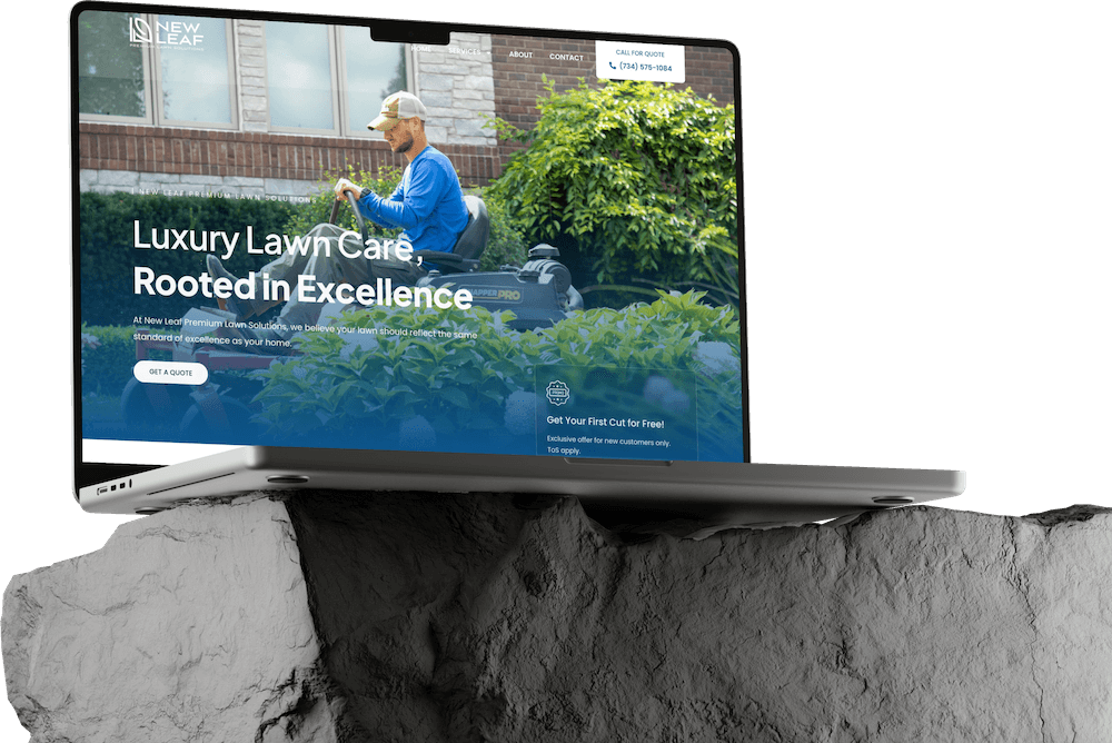 A laptop displaying a lawn care website in Dark Mode sits atop a jagged gray rock. The site shows a person tending to green plants with the headline "Luxury Lawn Care, Rooted in Excellence." Perfect inspiration for modern Website Builds.