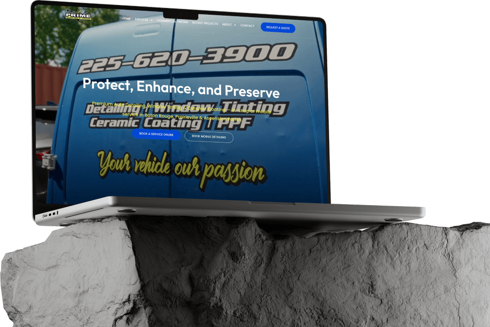 A laptop sits on a gray rock, displaying a website for Prime Auto detailing, window tinting, and ceramic coating. The blue van on the screen shows a phone number and the tagline, “Your vehicle our passion.” The sleek website features Dark Mode and showcases expert Website Builds tailored for automotive businesses.